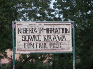 Sign reading 'NIGERIA IMMIGRATION SERVICE KIRAWA CONTROL POST'