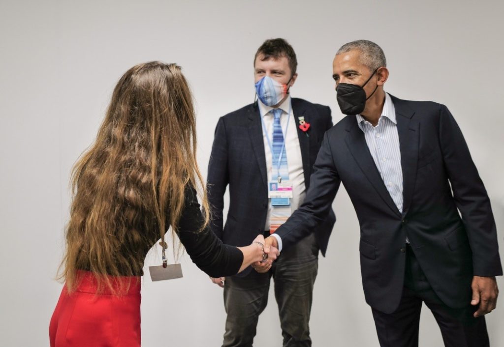 Fiona (with her back to us) is shaking hands with Barack Obama. Nigel Topping (1985), UN Climate Change High-Level Champion at COP26, is standing between them.
