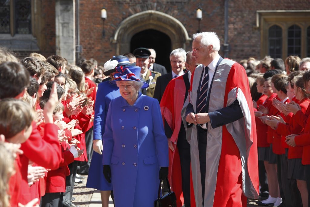The Queen (left) walking with former Master Chris Dobson through a crowd of clapping children from St John's College school.