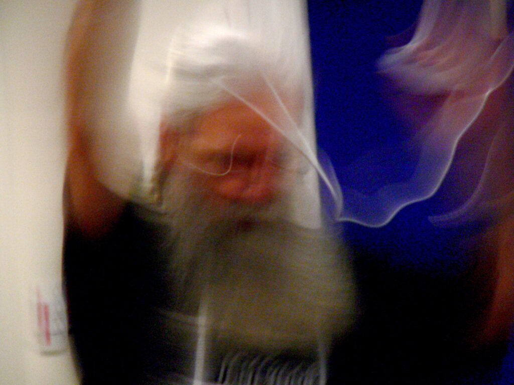 A slow exposure image of John waving his hands and some wire in the air