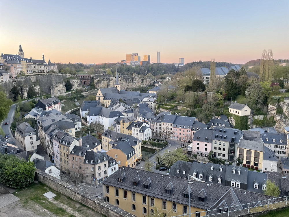 A zoomed out view of Luxembourg City with colourful, antiquated buildings. Modern buildings which house the EU institutions can be seen in the background.