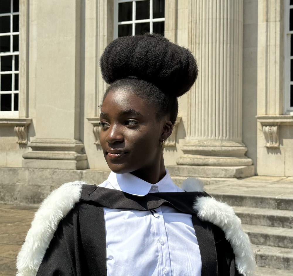 Blessings is dressed in graduation clothes outside Senate House.