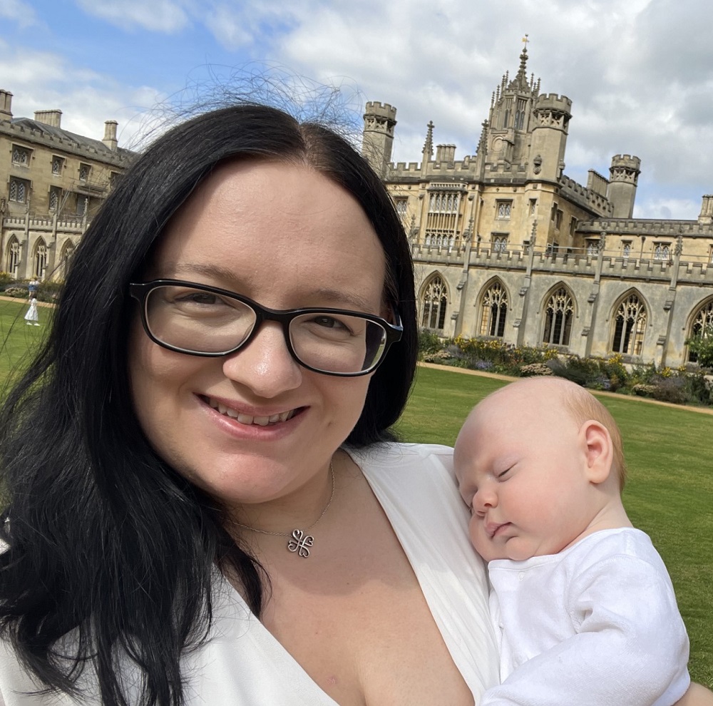 Victoria and her baby in front of the wedding cake building at St John's